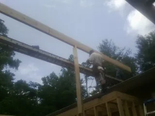 Carpenter setting a ridge beam over a new addition frame — Ice Dam Removal by Roofing Brothers in Whitney Point