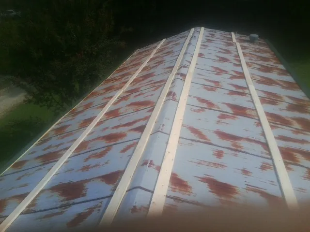 Rusted metal roof panels with new wood purlins before replacement — Storm Damage Roof Repair in Whitney Point by Roofing Brothers