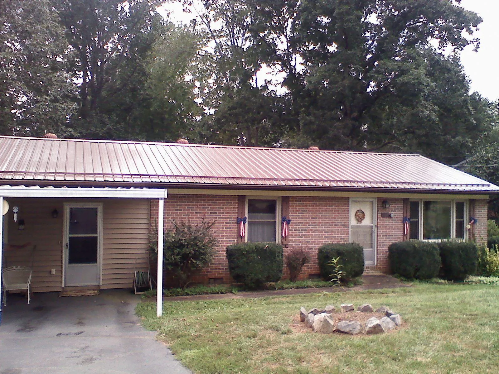 Bronze metal roof and carport on a brick ranch home — Roof Repair work by our crew in Whitney Point