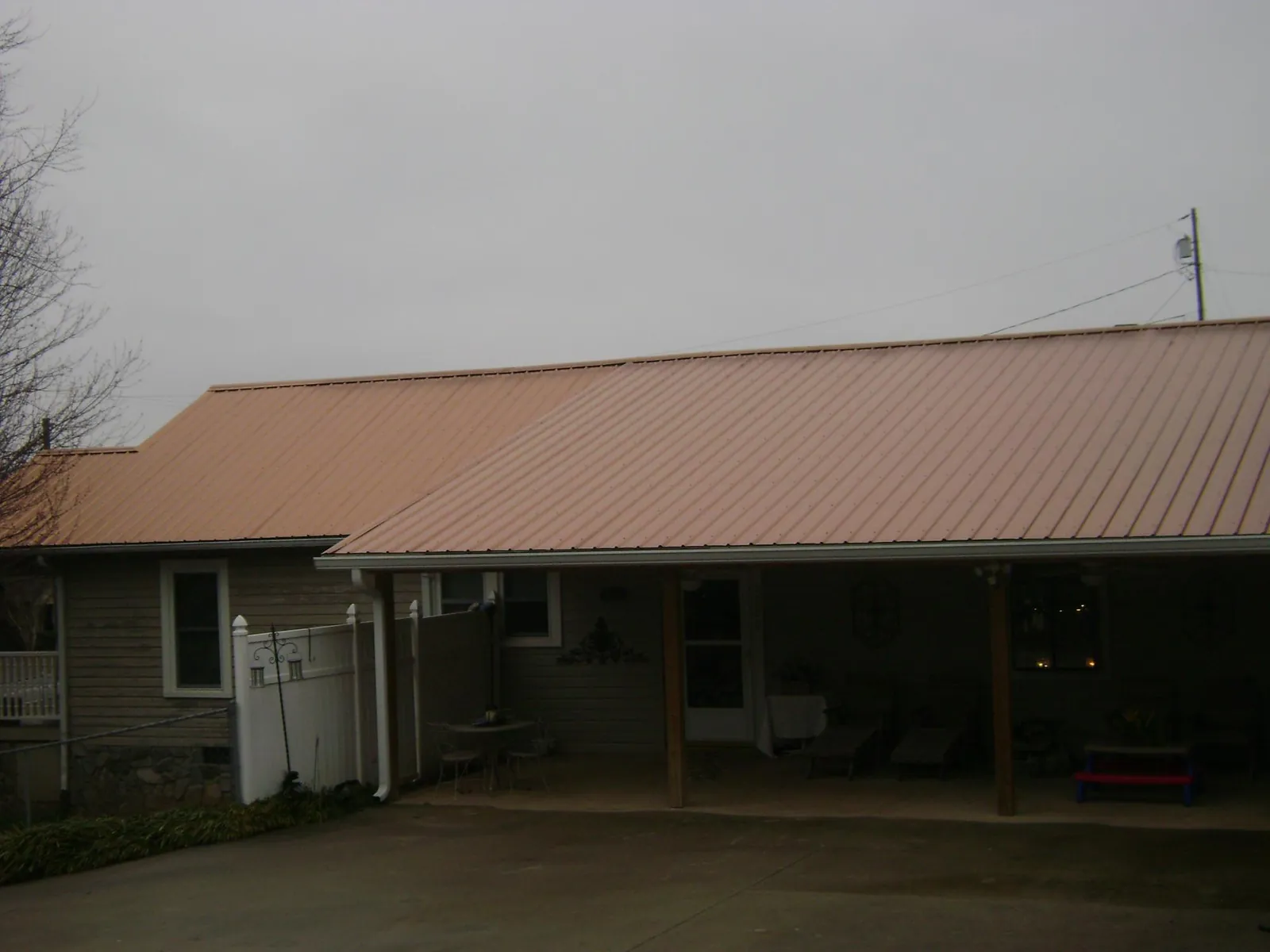 Copper toned metal roof over a wide covered patio in Whitney Point